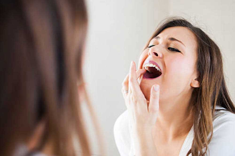 A woman Watching Her Teeth On the Mirror