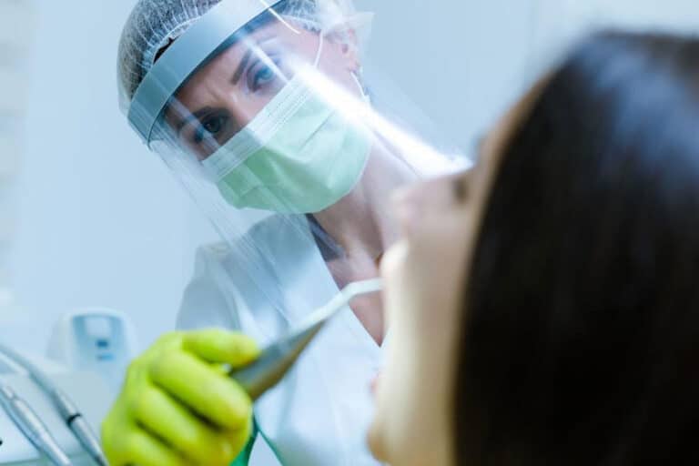 Dentist working with sheild for corona virus