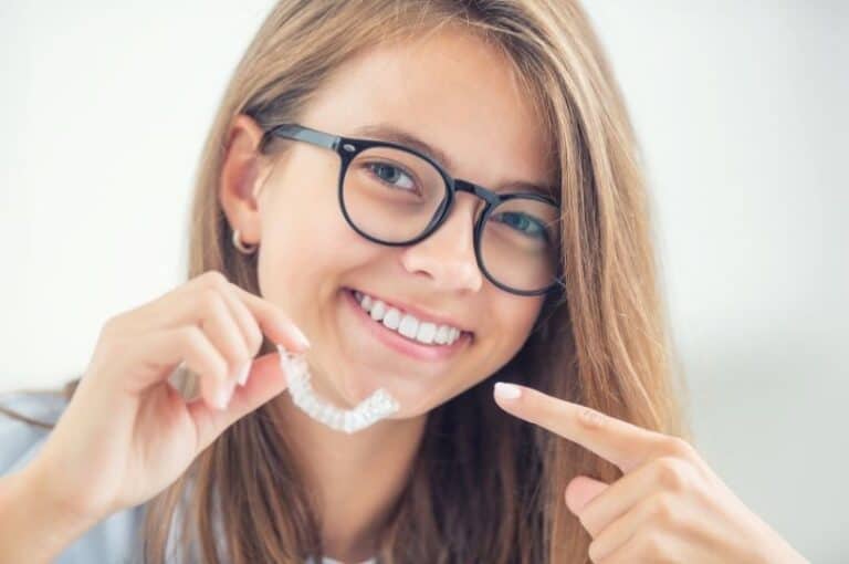 A young lady is pointing at an Invisalign