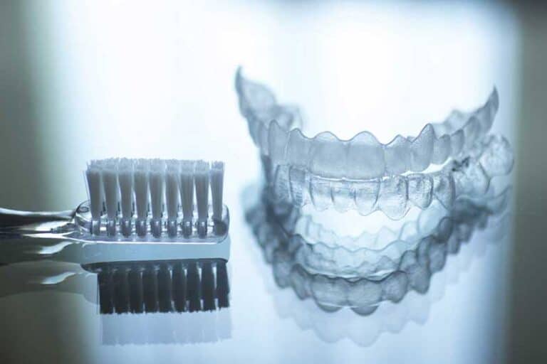 A cleaned invisalign retainer beside toothbrush